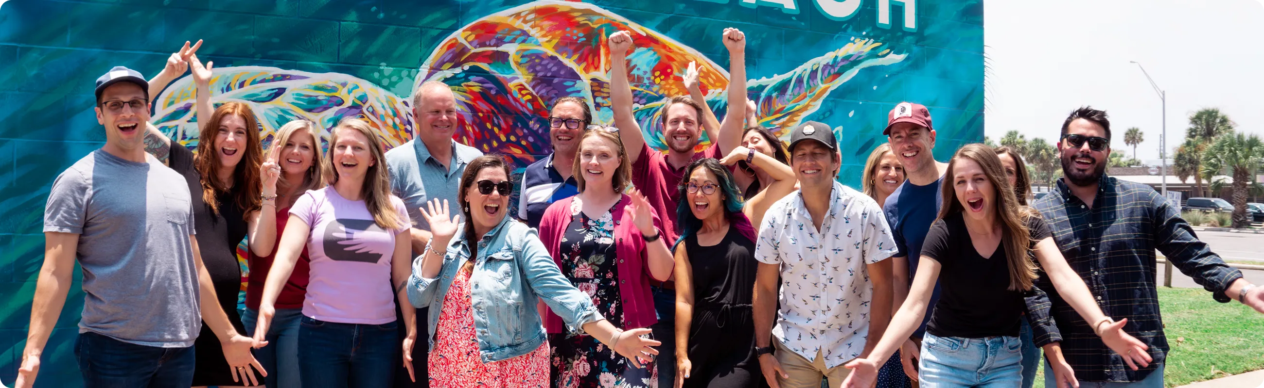 Employees standing in front of a mural